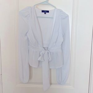 White front tie crop top with peplum detail and long sleeves!